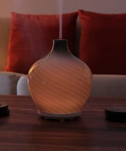 Leah diffuser by GreenAir on coffee table with warm white light and steam