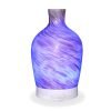 Aromar Decanter Abstract Bronze Diffuser with blue light on a white background