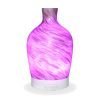 Aromar Decanter Abstract Bronze Diffuser with purple light on a white background
