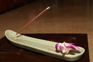 Cinnamon stick being burned in an incense burner.