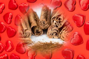 Cinnamon in love spells - cinnamon sticks and powder against a background of red hearts