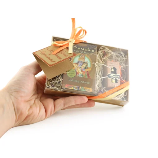 Oatmeal bar soap and manjari oil gift set held by a hand