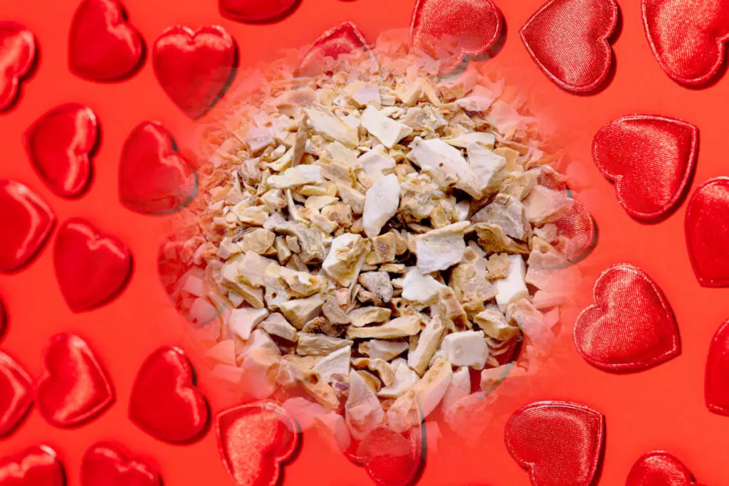 Orris root in love spells - chopped orris root on a background of red hearts